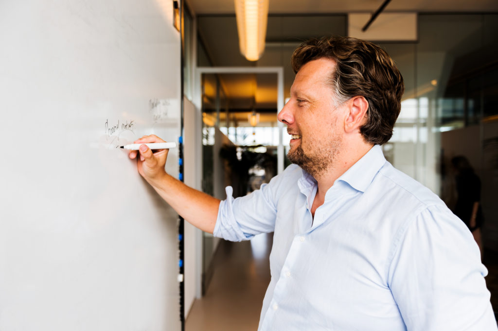 Employee writing maileon features on whiteboard