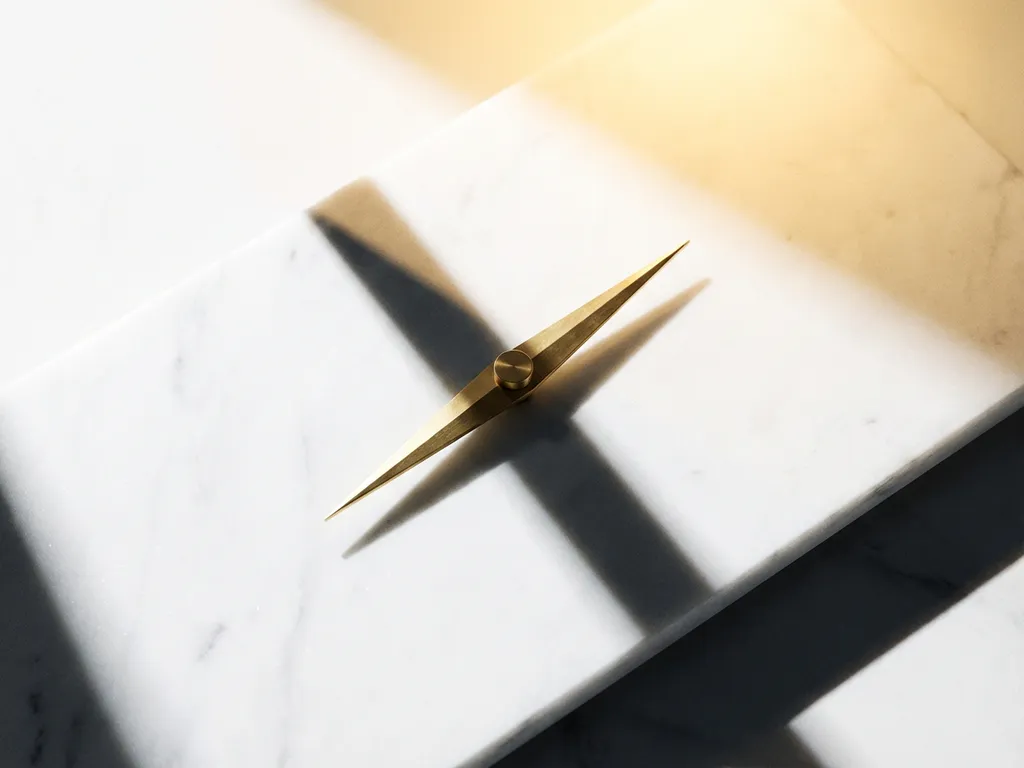 Messing kompasnaald in balans op wit marmer, wijzend naar gouden gloed, minimalistische compositie met geometrische schaduwen.